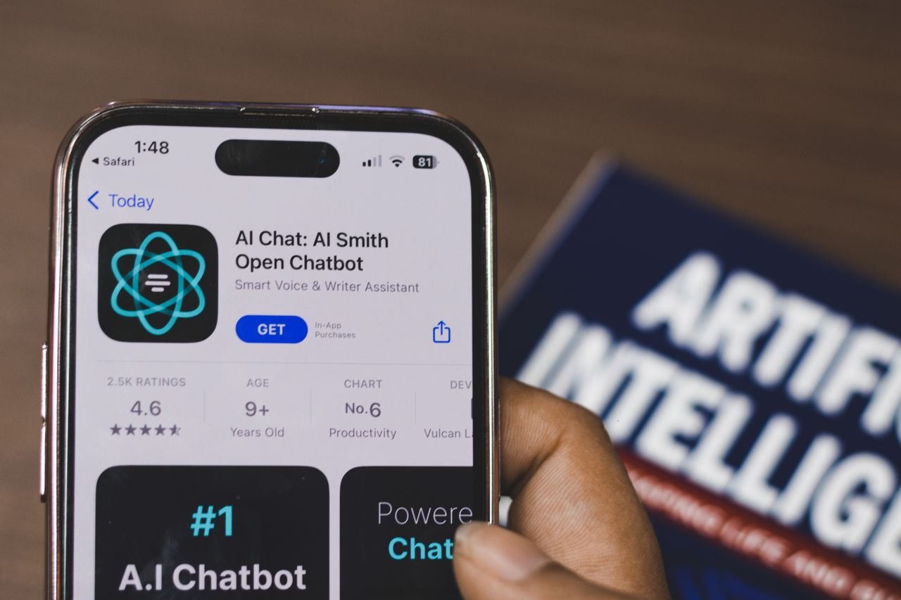 mission-img Hand holding a smartphone with AI chatbot app, emphasizing artificial intelligence and technology.
